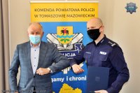 Komendant Powiatowy Policji w Tomaszowie Mazowieckim i Wójt Gminy Tomaszów siedzą przy stole konferencyjnym i podpisują umowę w sprawie służb ponadnormatywnych