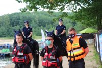 przedstawiciele WOPR i Straży Pożarnej w kamizelkach ratunkowych oraz policjantki na koniach