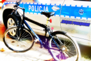 zdjęcie poglądowe roweru typu górskiego na tle policyjnego radiowozu