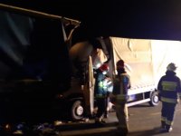 zdjęcia z miejsca wypadku drogowego na którym widać pojazd ciężarowy i wbity w naczepę pojazd dostawczy oraz pracujący na miejscu policjanci, strażacy i inne służby