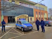 nowy radiowóz i trzech umundurowanych policjantów stoi na tle budynku Komendy Powiatowej Policji w Tomaszowie Mazowieckim