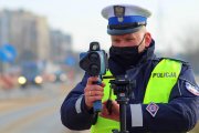 policjant ruchu drogowego mierzy prędkość pojazdów ręcznym miernikiem prędkości - zdjęcie od przodu