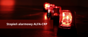 biały napis stopień alarmowy ALFA-CRP na czerwonym tle z widoczną sygnalizacją świetlną tzw. kogutami