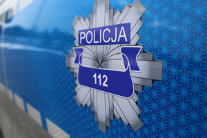 policyjna gwiazda z napisem policja 112 na niebiskim tle. zdjęcie wykonane pod skosem