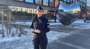 policjantka stoi na dworze z w tle metalowe serce