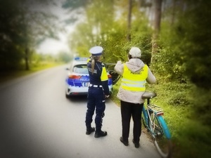 umundurowani policjanci ruchu drogowego rozdają niechronionym uczestnikom ruchu drogowego elementy odblaskowe