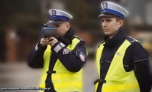 policjanci ruchu drogowego podczas pomiaru prędkości  laserowym miernikiem prędkości