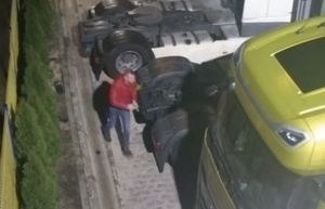 osoba w czerwonej kurtce, która chodzi przy pojazdach ciężarowych