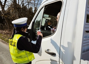 policjantka ruchu drogowego przekazuje kierowcy zapachowe serduszko