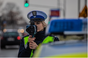 policjantka ruchu drogowego mierzy prędkość laserowym miernikiem prędkości