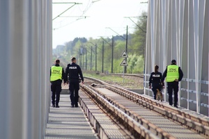 policjanci i strażnicy ochrony kolei wraz z psem służbowym patrolują obszary kolejowe