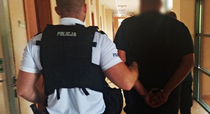 policjanci prowadzą zatrzymanego mężczyznę