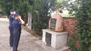 policjanci oddają cześć poległym policjantom przed obeliskiem na cmentarzu wojennym w Tomaszowie Mazowieckim