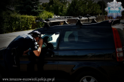Policjant zaglądający do wnętrza samochodu przez zamkniętą szybę