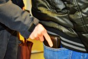 zdjęcie poglądowe na którym widać dłoń męską która z tylnej kieszeni spodni innej osoby wyjmuje portfel