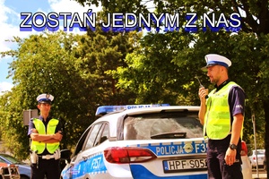 umundurowani policjanci ruchu drogowego w białych czapkach i odblaskowych kamizelkach stoją przy oznakowanym radiowozie. Jeden z policjantów rozmawia przez ręczną radiostację u góry napis zostań jednym z nas
