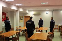 nowo przyjęci policjanci w mundurach i Komendant Powiatowy Policji w Tomaszowie Mazowieckim stoją na sali odpraw w budynku jednostki i rozmawiają