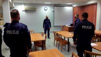 nowo przyjęci policjanci w mundurach i Komendant Powiatowy Policji w Tomaszowie Mazowieckim stoją na sali odpraw w budynku jednostki i rozmawiają