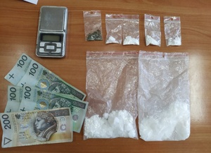 zabezpieczone przez policjantów do sprawy dowody, to jest w lewym górnym rogu waga elektroniczna, poniżej polskie banknoty, w pozostałej części obrazu sześć torebek foliowych z białym proszkiem