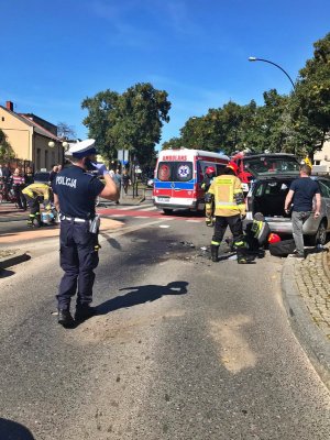 policjant a w tle karetka i strażacy