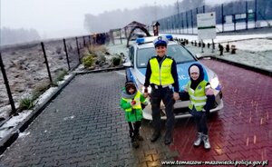 policjantka ruchu drogowego w ramach prowadzonych działań wręcza elementy odblaskowe pieszym i rowerzystom