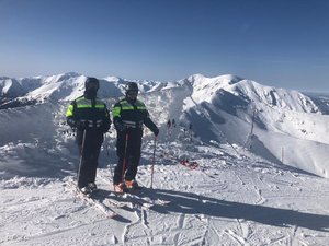 policjanci na nartach stoją na ośnieżonym stoku