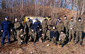 policjanci prowadzą spotkanie edukacyjno-doborowe z młodymi osobami przynależnymi do Strzelca. Młodzież ubrana w zielone mundury