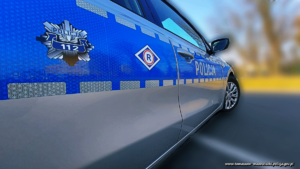 radiowóz z policyjną gwiazdą na drzwiach oraz emblematem ruchu drogowego