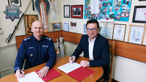 Komendant Powiatowy Policji w Tomaszowie Mazowieckim inspektor Szymon Herman przy stole wspólnie z Wójtem Inowłodza Bogdanem Kąckim podpisuje porozumienie o dodatkowych policyjnych służbach
