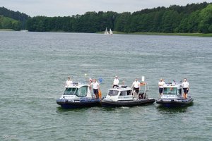 trzy policyjne łodzie z policjantami na pokładzie na akwenie