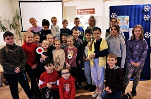 policjantka prowadzi spotkanie z uczestnikami półkolonii w bibliotece