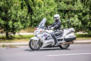 Funkcjonariusz Policji jadący na motocyklu.