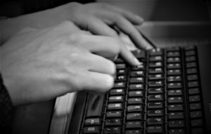 dłonie na klawiaturze komputerowej, zdjęcie czarno-białe