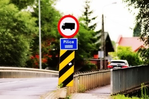 fotografia przedstawiająca ruch pojazdów oraz znak drogowy zakazujący wjazdu pojazdów ciężarowych