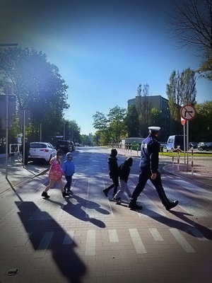 policjanci ruchu drogowego uczą dzieci przechodzić przez przejście dla pieszych