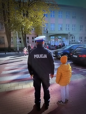 policjanci ruchu drogowego uczą dzieci przechodzić przez przejście dla pieszych