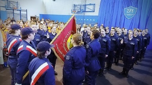 pierwszoklasiści z klasy policyjnej ślubują na sztandar szkoły. Na sali duża liczba uczniów innych klas i zaproszonych gości