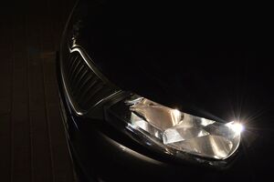 lewy reflektor przedni w aucie osobowym świeci w ciemności