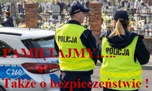 cmentarz. Na pierwszym planie, odwróconych tyłem,  stoi dwoje umundurowanych policjantów. Na zdjęciu widnieje napis Pamiętajmy... także o bezpieczeństwie."