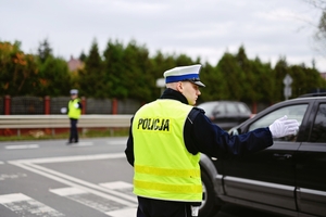 na zdjęciu policjant ruchu drogowego kieruje ruchem w rejonie nekropolii
