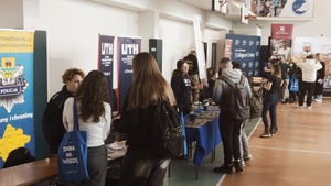 policjanci przy stoisku rozmawiają z uczestnikami targów akademickich
