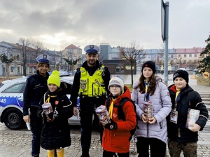policjanci ruchu drogowego z kwestującymi na rzecz Wielkiej Orkiestry Świątecznej Pomocy