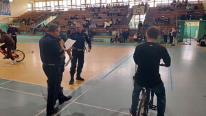 zmagania uczestników turnieju na hali sportowej nadzorowane przez policjantów