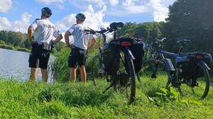 Policjanci stoją nad wodą, obok stoją policyjne rowery