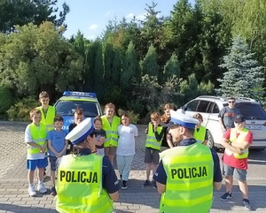 policjanci ruchu drogowego mówią do uczniów zgromadzonych na egzaminach na kartę rowerową