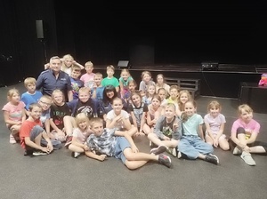 policjanci podczas prelekcji siedzą z dziećmi na podłodze