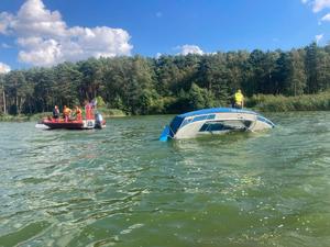 Przewrócona łódź i udzielający pomocy ratownicy WOPR