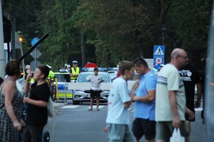 policjanci ruchu drogowego regulujący przejazd pojazdów zapewniają bezpieczeństwo pieszym