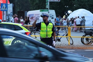 policjanci ruchu drogowego regulujący przejazd pojazdów zapewniają bezpieczeństwo pieszym