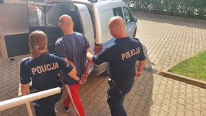 policjanci prowadzą zatrzymanego mężczyznę